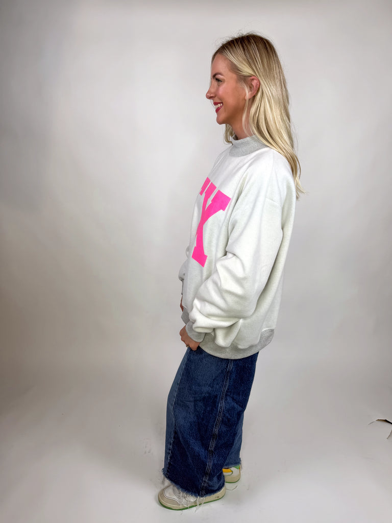 model wearing reversible texas sweatshirt with pink TX and gray TEXAS sides