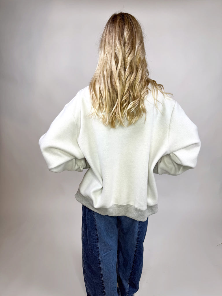 model wearing reversible texas sweatshirt with pink TX and gray TEXAS sides