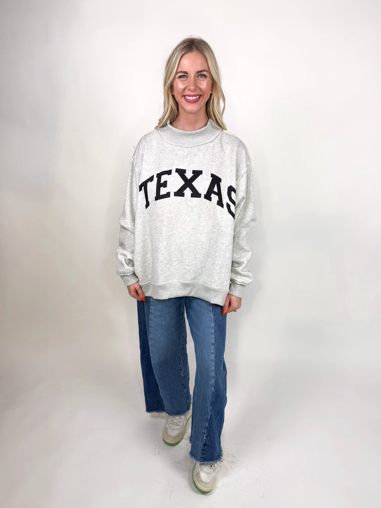 model wearing reversible texas sweatshirt with pink TX and gray TEXAS sides