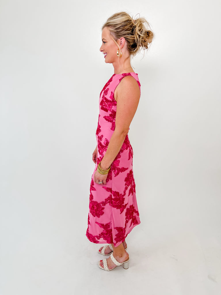 Sleeveless pink midi dress with bold embroidered fuchsia florals, high neckline and feminine fit, perfect for spring events or weddings