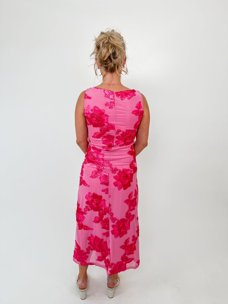 Sleeveless pink midi dress with bold embroidered fuchsia florals, high neckline and feminine fit, perfect for spring events or weddings