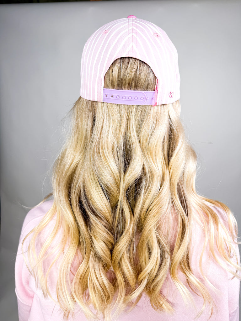 model wearing Saved by Grace Cap with pink and white stripes and lime green embroidered text