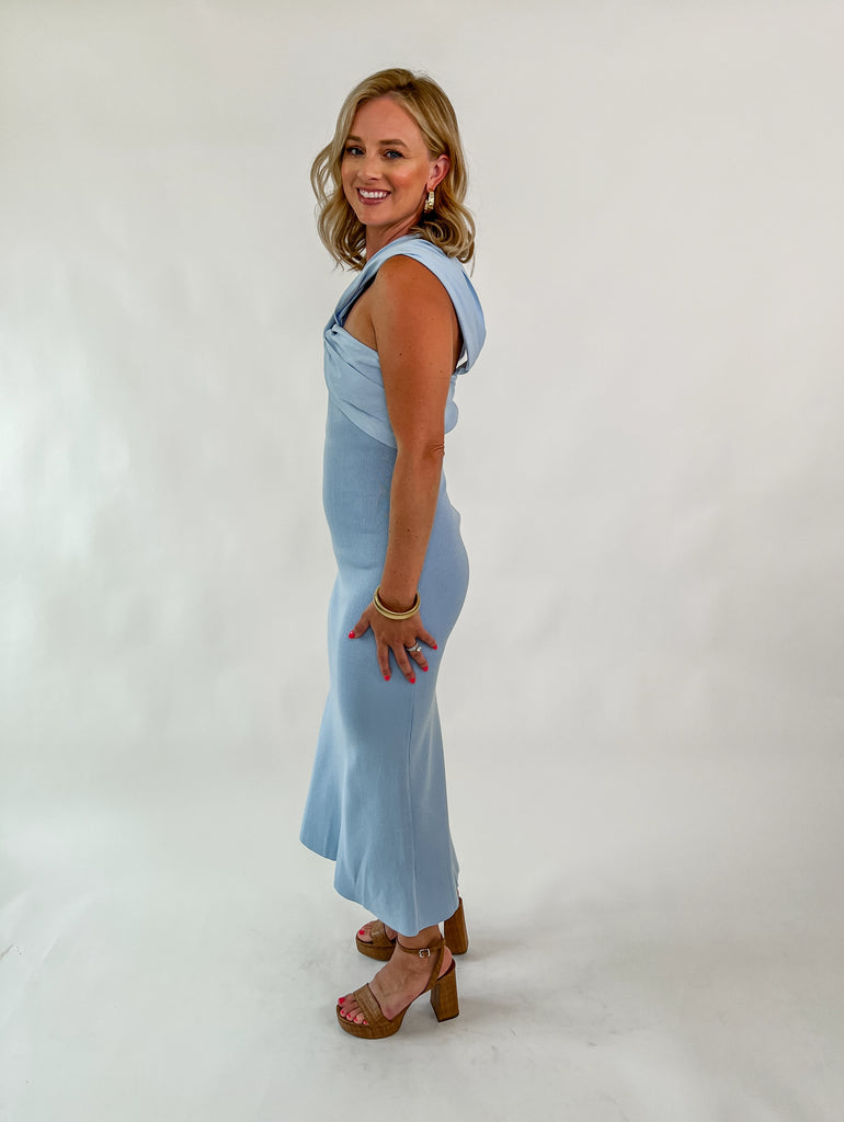 woman wearing light blue sleeveless midi dress with twisted knot neckline