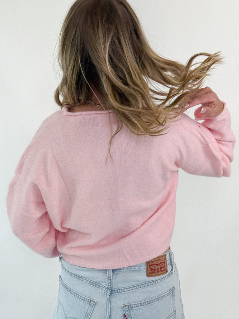 Pink knit sweater top with embroidered strawberries and button-up front