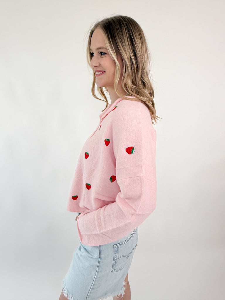 Pink knit sweater top with embroidered strawberries and button-up front