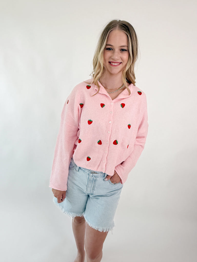 Pink knit sweater top with embroidered strawberries and button-up front