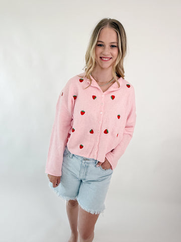 Pink knit sweater top with embroidered strawberries and button-up front