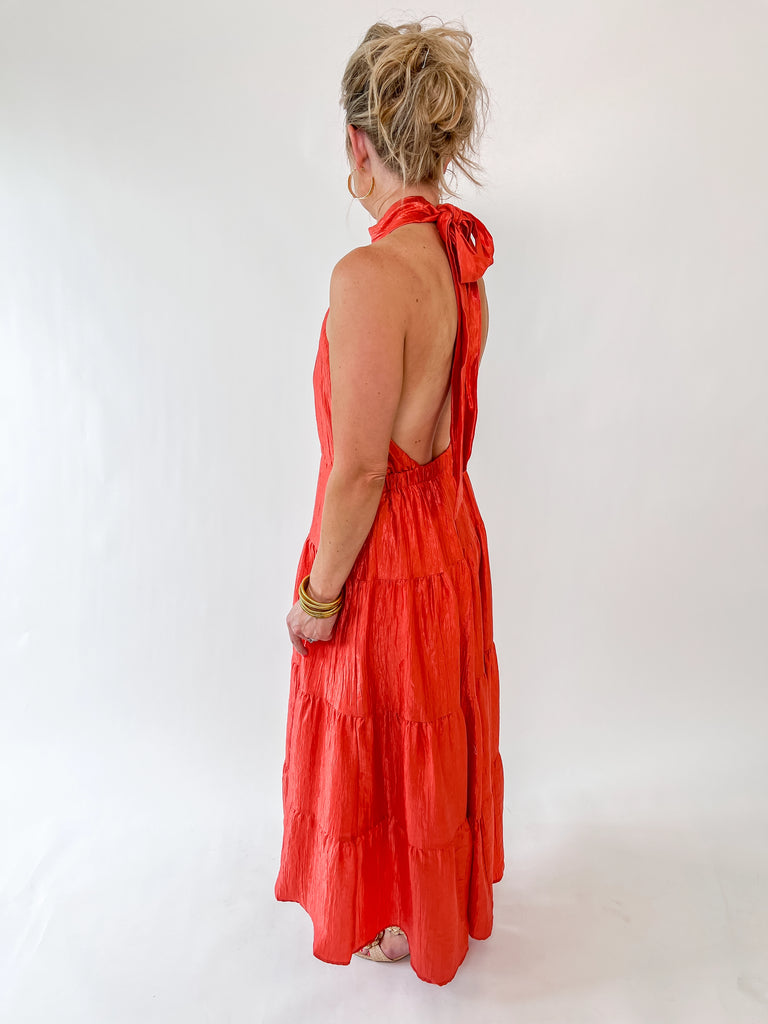 Vibrant orange halter maxi dress with tie-back detail and tiered skirt – perfect for weddings, parties, and summer events
