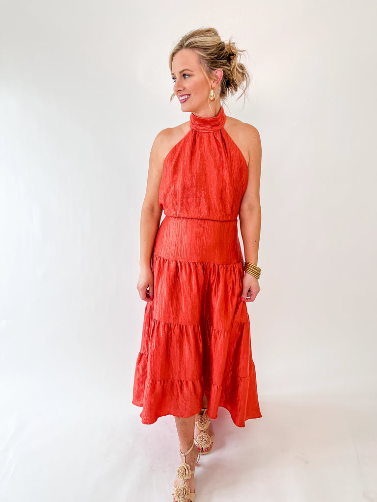 Vibrant orange halter maxi dress with tie-back detail and tiered skirt – perfect for weddings, parties, and summer events