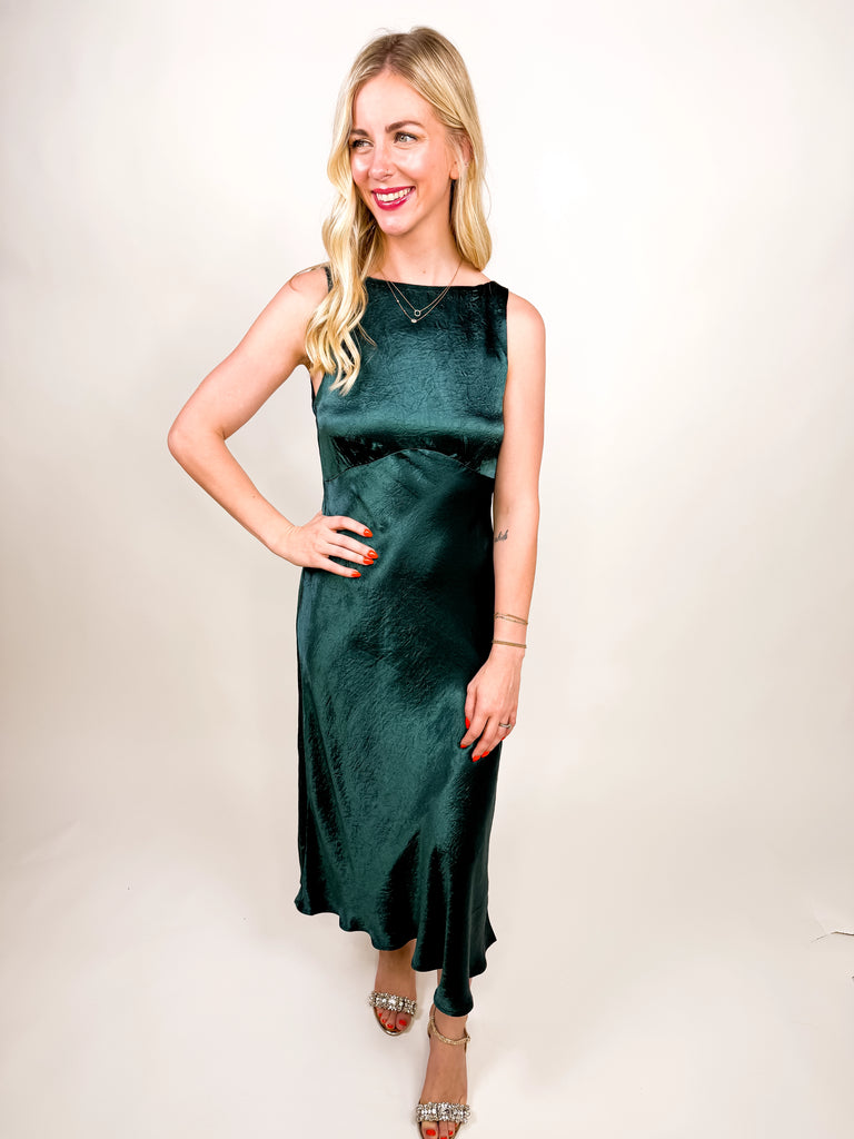 The Emerald Satin Midi Dress in deep green satin featuring a sleek silhouette and open V-back