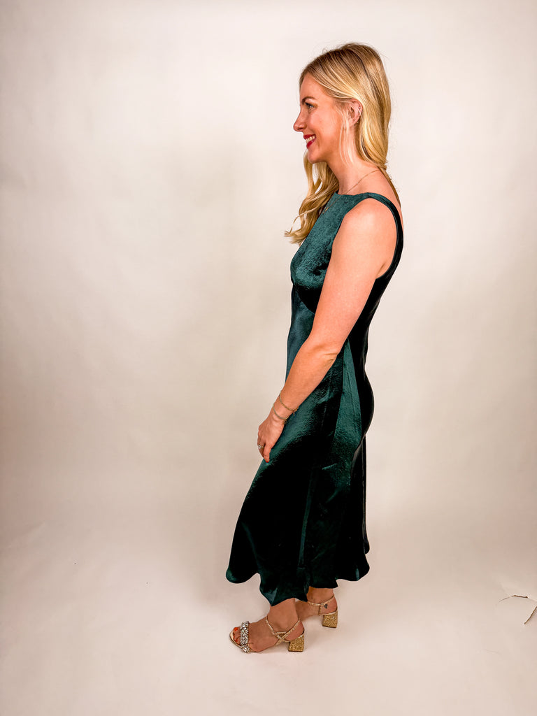 The Emerald Satin Midi Dress in deep green satin featuring a sleek silhouette and open V-back