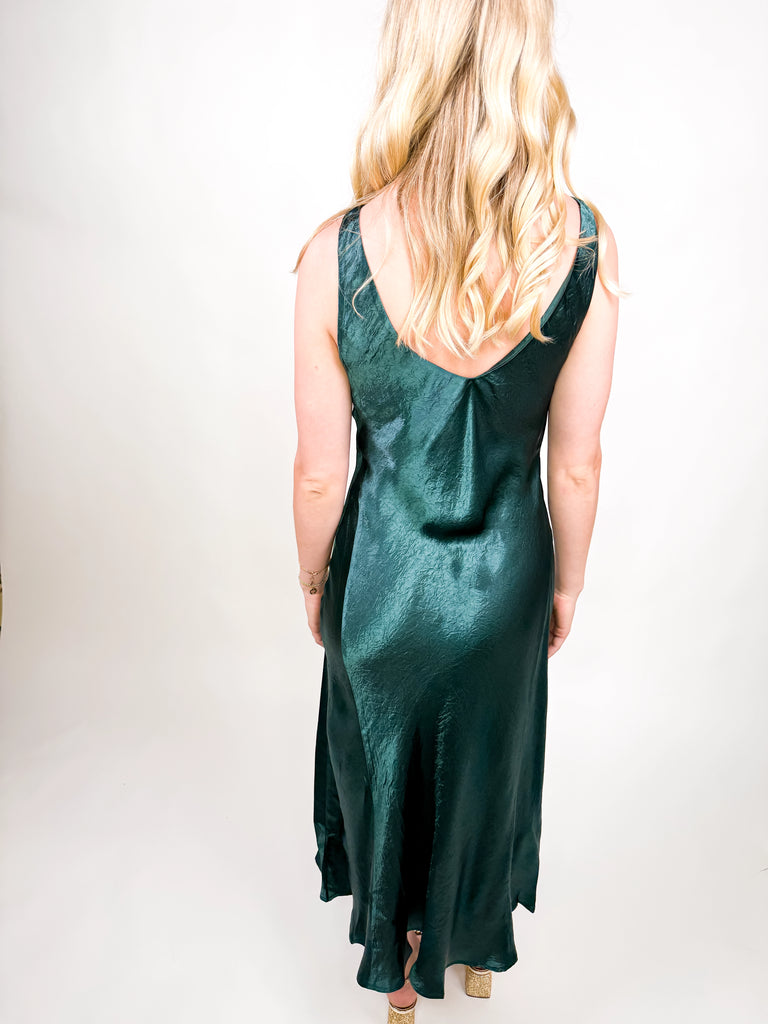 The Emerald Satin Midi Dress in deep green satin featuring a sleek silhouette and open V-back