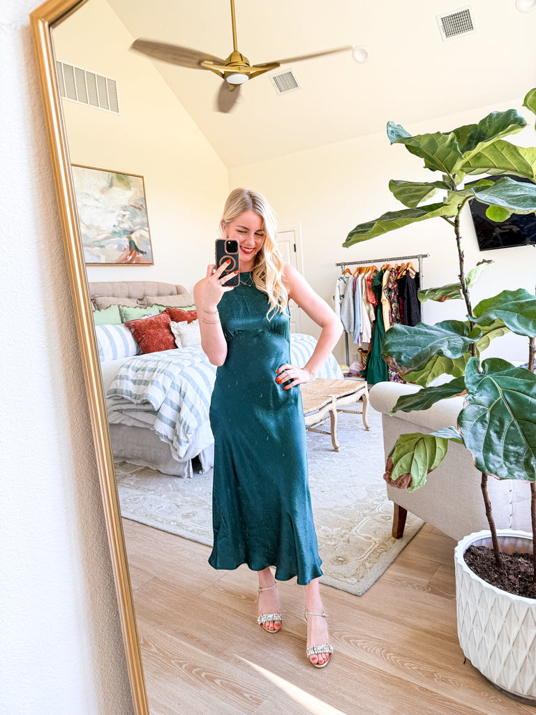 The Emerald Satin Midi Dress in deep green satin featuring a sleek silhouette and open V-back