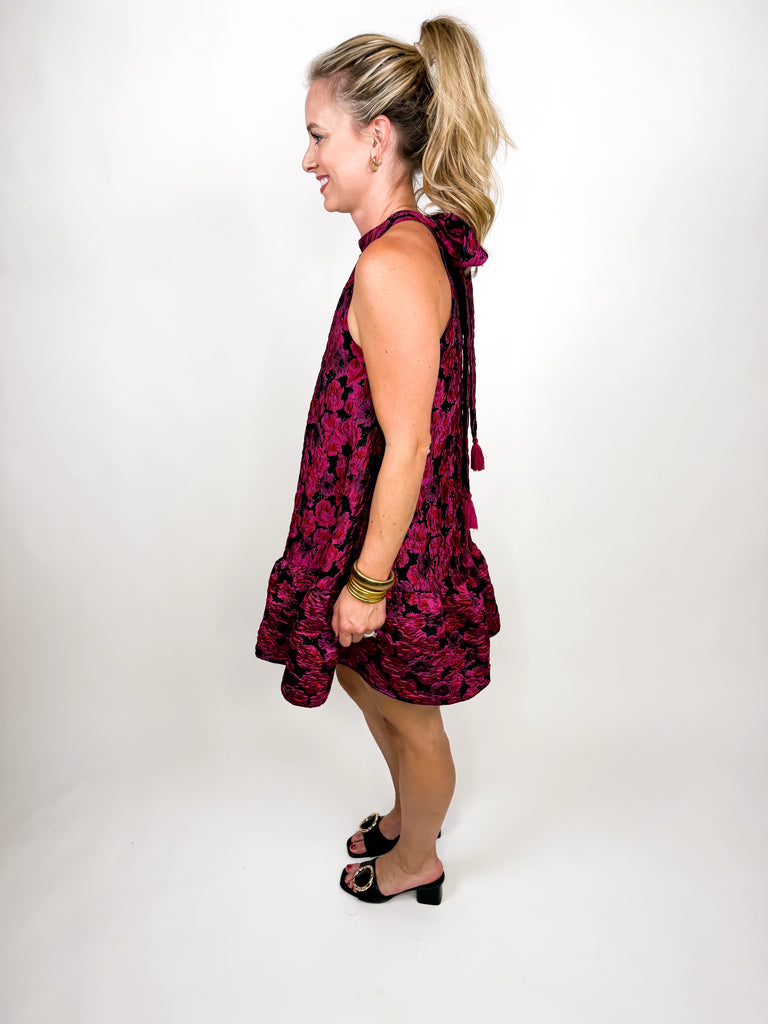 model wearing The Juliette Tassel Dress in magenta floral jacquard with tassel tie back