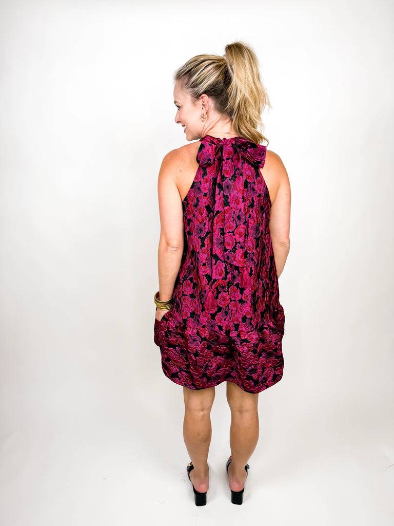 model wearing The Juliette Tassel Dress in magenta floral jacquard with tassel tie back