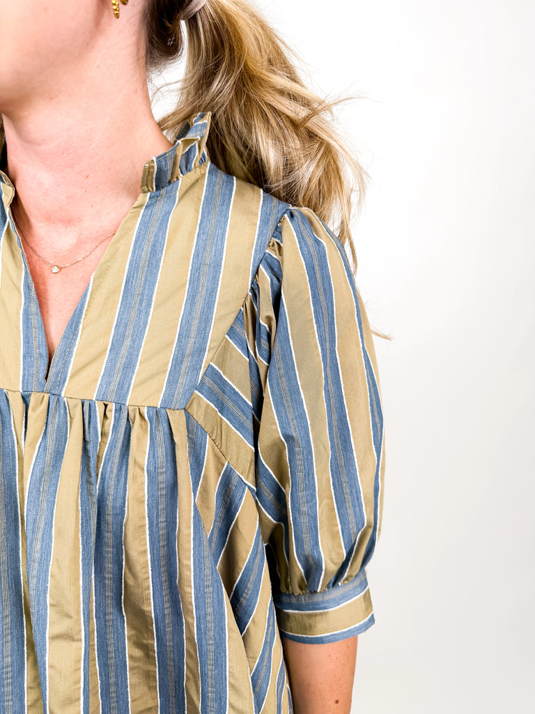 The Marlowe Stripe Dress featuring blue and camel vertical stripes with a ruffled neckline and puff sleeves