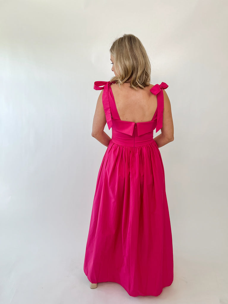 Woman wearing The Whitney Dress – hot pink satin maxi with shoulder bows