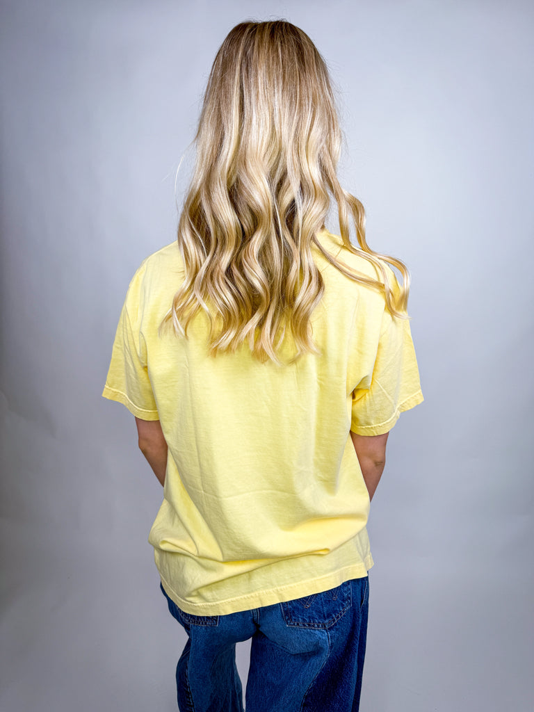 Woman wearing yellow Trick and Treat Comfort Colors Halloween graphic tee