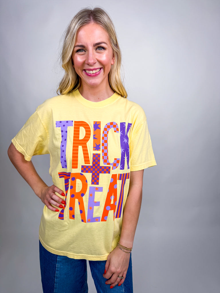 Woman wearing yellow Trick and Treat Comfort Colors Halloween graphic tee