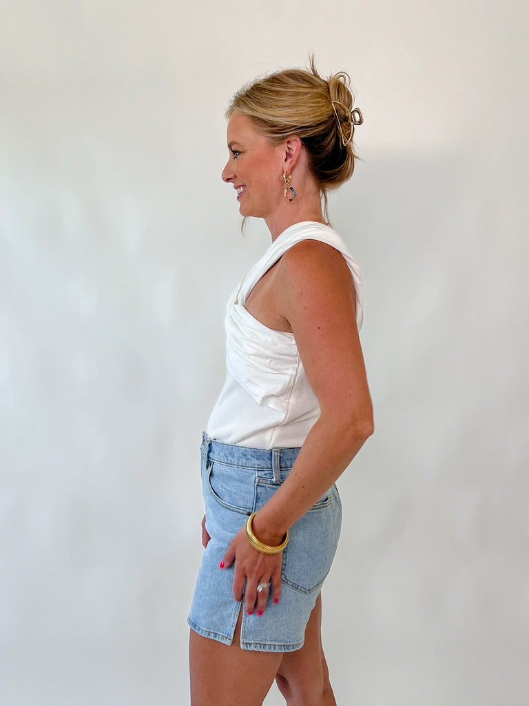 Woman wearing ivory twist-front sleeveless bodysuit with crossover straps