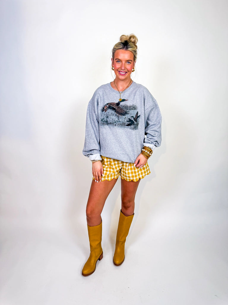 Woman wearing Wild Wing Pullover in heather gray with flying duck graphic